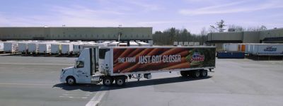 Large red truck carrying goods from a warehouse to the supermarket, Northeast Grocery | DXC Technology Customer Stories